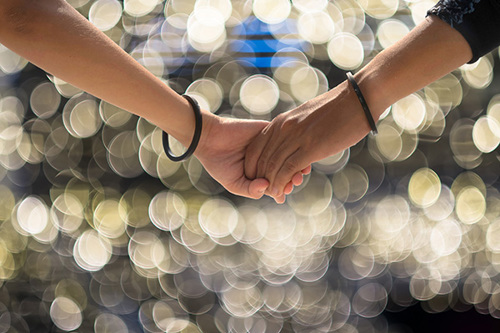 Holding hands with sparkling lights