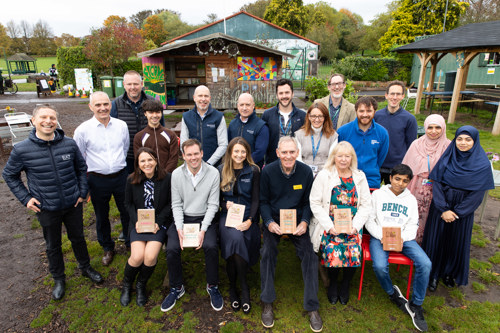 A group of Bee Bold 2024 winners smile with their awards at Redcatch Community Garden in Knowle, Bristol