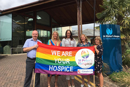 Staff members with the Pride banner